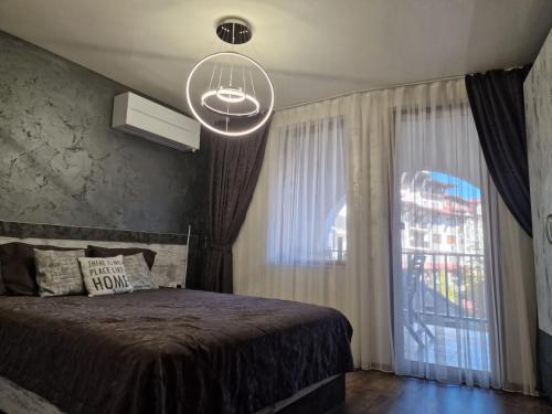 1 dormitorio con cama y ventana grande en Luxe Apartment Grand Monastery in Pamporovo, en Pamporovo
