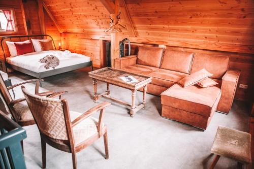 uma sala de estar com um sofá e uma cama em CRASH'NSTAY - The Silo Bungalow em Sprang-Capelle