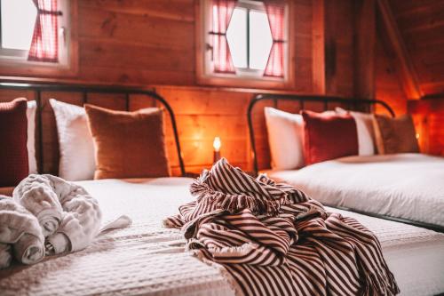 two beds in a bedroom with a candle on the bed at CRASH'NSTAY - The Silo Bungalow in Sprang-Capelle
