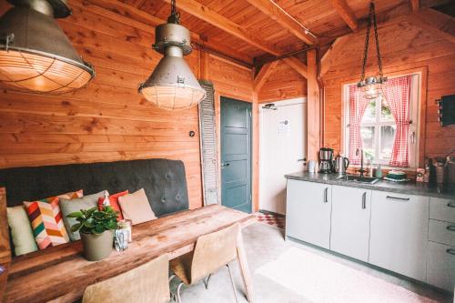 a kitchen and dining room in a log cabin at CRASH'NSTAY - The Silo Bungalow in Sprang-Capelle