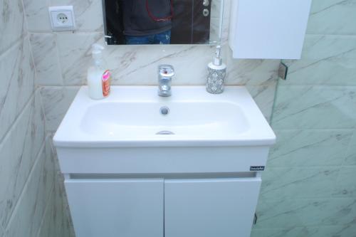 a white sink in a bathroom with a mirror at Soleil & Piscine BOUZNIKA in Bouznika