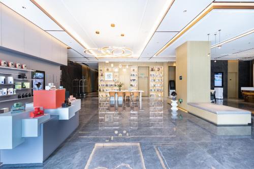 a lobby of a store with a table and chairs at Atour Hotel Yibin West Railway Station in Yibin