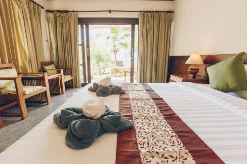 a hotel room with a bed with towels on it at Krabi Sands Resort in Klong Muang Beach