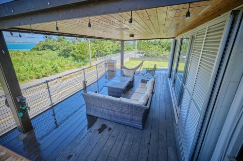 a screened in porch with a couch and a table at Beach Side Secret in Ginoza