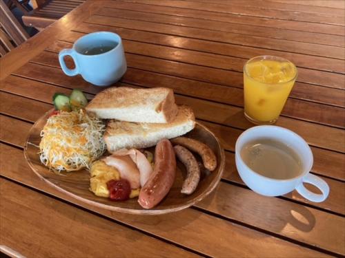a plate of breakfast food and a cup of orange juice at Ocean Resort PMC in Onna