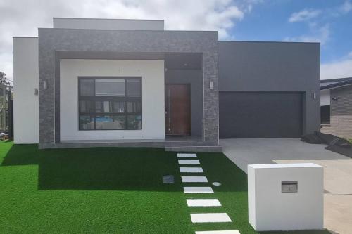 a rendering of a house with a green lawn at Beautiful New home in Throsby with 5 Bedrooms in Harrison