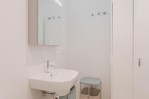 ein Badezimmer mit einem Waschbecken, einem Spiegel und einem Stuhl in der Unterkunft Marsalada - Ground floor front line beach apartment in Playa de Mar