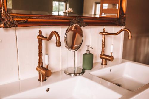 a bathroom sink with two faucets and a mirror at CRASH'NSTAY - 't Silo Huis in Sprang-Capelle