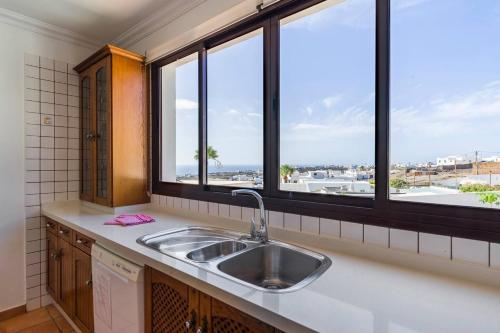a kitchen with a sink and two windows at Casa Bellavista in Tías