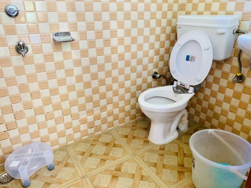 a bathroom with a toilet and a trash can at Hostel 360 Degree in Manāli