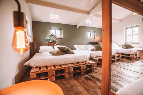 um quarto com quatro camas sentadas em paletes em CRASH'NSTAY - 't Silo Huis em Sprang-Capelle