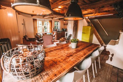 CRASH'NSTAY - 't Silo Huis في Sprang-Capelle: غرفة طعام مع طاولة وكراسي خشبية