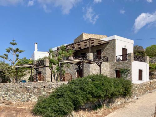 a house on a stone wall with a balcony at SYROU LOTOS Studios & Apartments in Kinion
