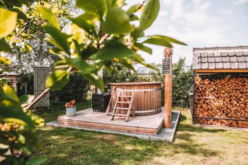 a wooden deck with a chair on it in a yard at CRASH'NSTAY - 't Silo Huis in Sprang-Capelle