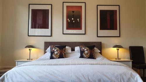 a bedroom with a bed with four pictures on the wall at Spacious Central London 2 Bedroom Mansion Block Apartment in London