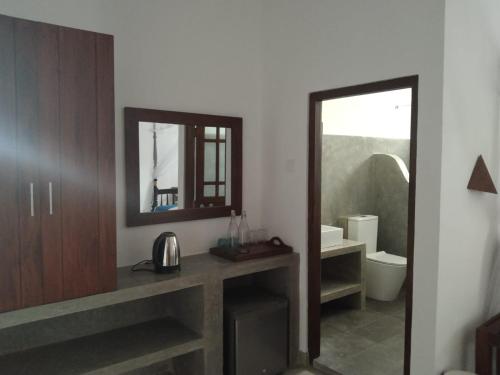 y baño con lavabo, espejo y aseo. en Beach Inns Holiday Resort - Celeste, en Matara