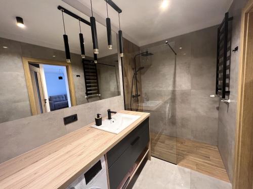 a bathroom with a sink and a shower at Apartament na Zielonej Szczytno Mazury in Szczytno