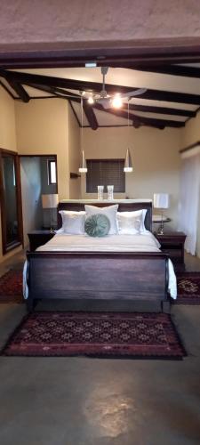 a bedroom with a large bed in a room at Bee-Eater Cottage, DaGama Dam in White River