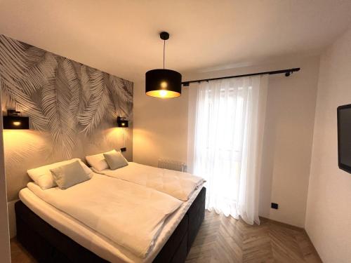 a bedroom with a large bed and a window at Apartament na Zielonej Szczytno Mazury in Szczytno