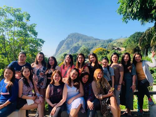 a group of women posing for a picture with mountains in the background at Rock View Hostel Ella in Ella