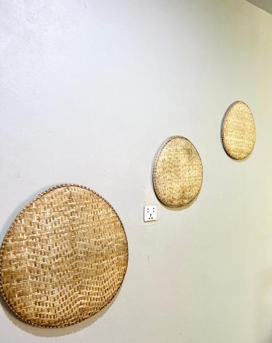 three rattan toilet bowls on a wall at Angkor Piseth Homestay in Siem Reap