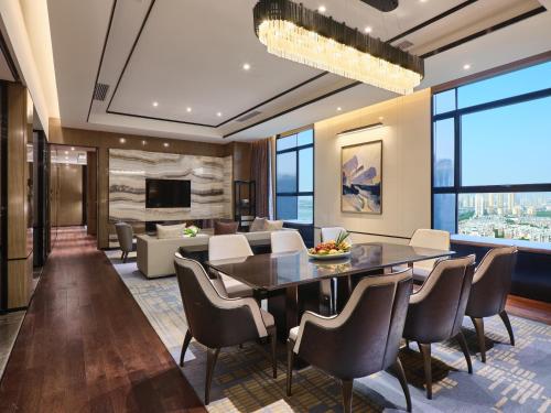 uma sala de jantar e sala de estar com mesa e cadeiras em Crowne Plaza Wuhan Development Zone, an IHG Hotel em Wuhan