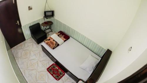 einen Blick über ein Zimmer mit einem Bett und einem Stuhl in der Unterkunft HOTEL HERITAGE in Chittagong
