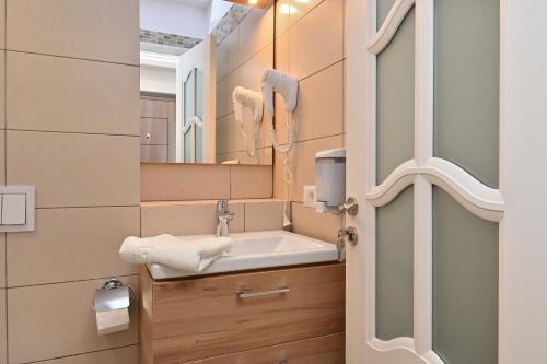 uma casa de banho com um lavatório e um espelho em Durau Residence em Piatra Neamţ