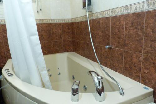 a bath tub with a shower curtain and a sink at Accommodation in the historical center of Riga in Riga