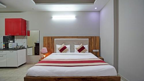 a bedroom with a large bed and a kitchen at The Palm Suites - Medicity in Gurgaon