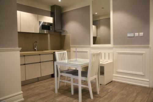 a kitchen with a white table and two chairs at Aswar Boutique Hotel in Al Khobar