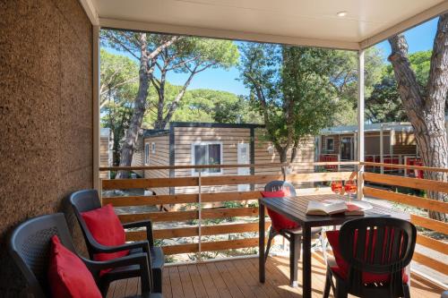 a patio with a table and chairs on a deck at Camping Il Capannino Glamping Village in Marina di Bibbona