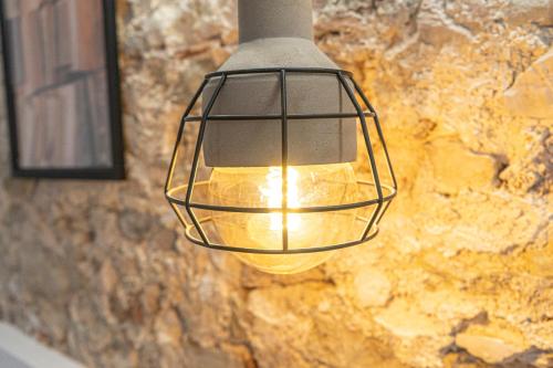 aendant light hanging from a stone wall at Apartamentos BocairentHomes, en pleno centro de Bocairent, con pequeña piscina y parking privado in Bocairent