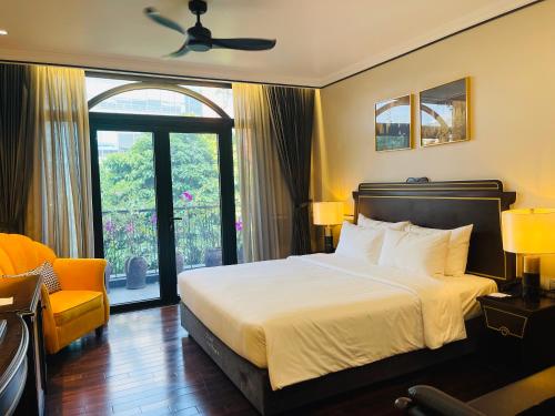 a bedroom with a bed and a chair and a window at Hotel du Monde Art in Hanoi