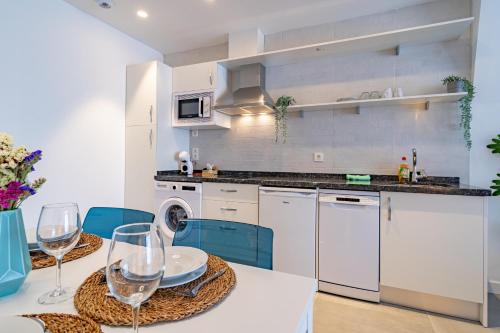 a kitchen with a table with wine glasses on it at Edificio Santiago by Plaza Mayor Apartamentos in Valladolid