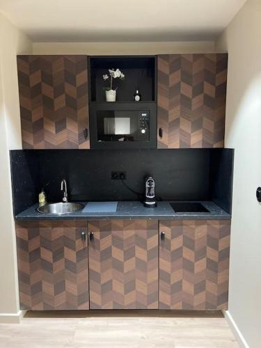 - une cuisine avec un évier et un miroir dans l'établissement Bordeaux: Le Joyau de Cerf Volant, à Bordeaux