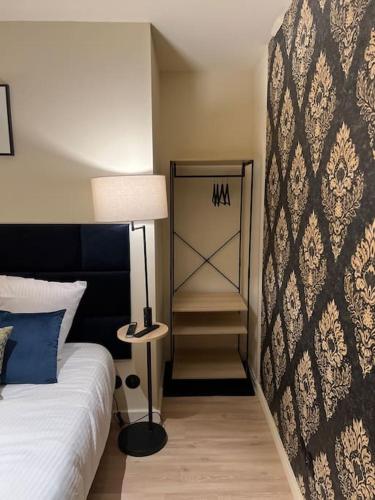 - une chambre avec un lit doté d'une lampe et d'un miroir dans l'établissement Bordeaux: Le Joyau de Cerf Volant, à Bordeaux