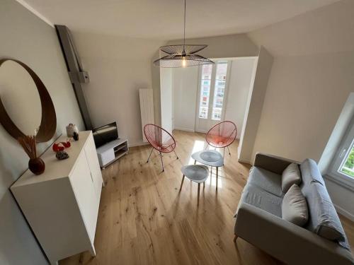 uma sala de estar com um sofá, cadeiras e um espelho em Le Dolce 65m2 Centre de Dijon 4 personnes em Dijon