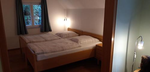 a small bed in a bedroom with a window at Ferienwohnung Koch in Odenthal