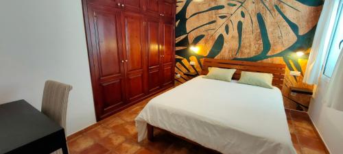 a bedroom with a white bed and a painting on the wall at Villa Fedelian 2 Playa Blanca in Playa Blanca