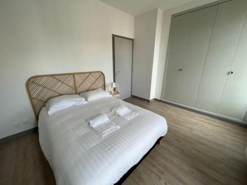 une chambre avec un lit blanc avec deux serviettes dessus dans l'établissement Le Dolce 65m2 Centre de Dijon 4 personnes, à Dijon