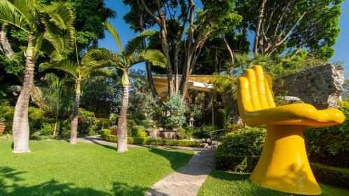 a yellow statue of a hand in a garden at Holiday Inn Cuernavaca by IHG in Cuernavaca
