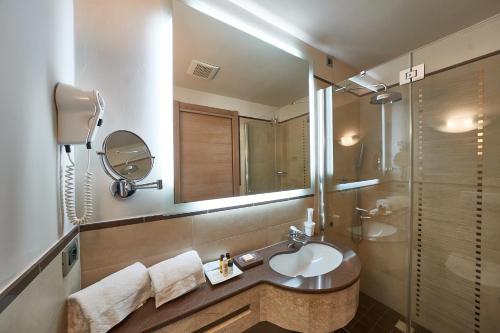 a bathroom with a sink and a mirror at Hotel Astoria in Biella