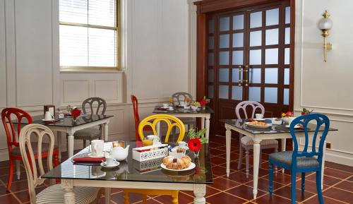 a dining room with tables and chairs with food on them at Hotel Astoria in Biella