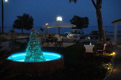 a blue christmas tree in a pool at night at Land of Gods in Gythio