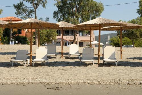 a group of chairs and umbrellas on a beach at Land of Gods in Gythio