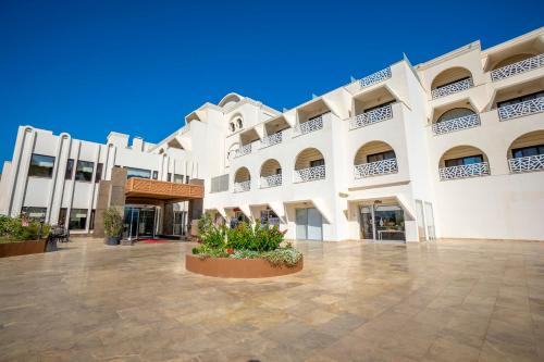 a large white building with a large courtyard at Azka Hotel in Bodrum City