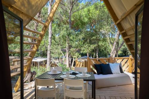 a patio with a couch and a table and chairs at Camping Il Capannino Glamping Village in Marina di Bibbona