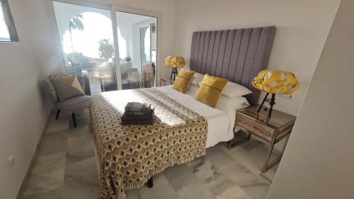 a bedroom with a bed with yellow pillows and a table at 240 Front line beach La Cala in La Cala de Mijas