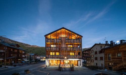 a large building with glass windows on a city street at Hotel Larice in Livigno